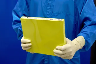 An employee holds a full-size prototype LMR battery cell at the General Motors Wallace Battery Cell Innovation Center. (Photo by Steve Fecht for General Motors)